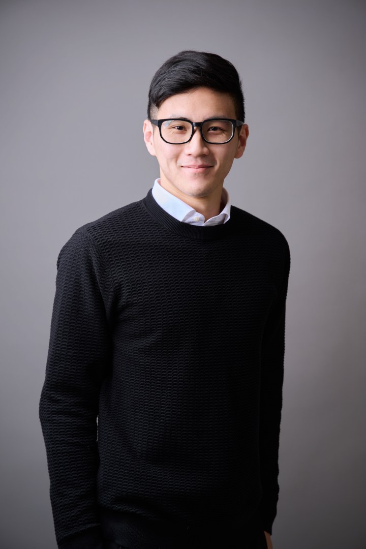 台南專業形象照推薦：親切男性商務形象攝影。穿著黑色針織衫與襯衫，戴黑框眼鏡，展現自信微笑。適合求職、社群頭像或個人品牌經營。