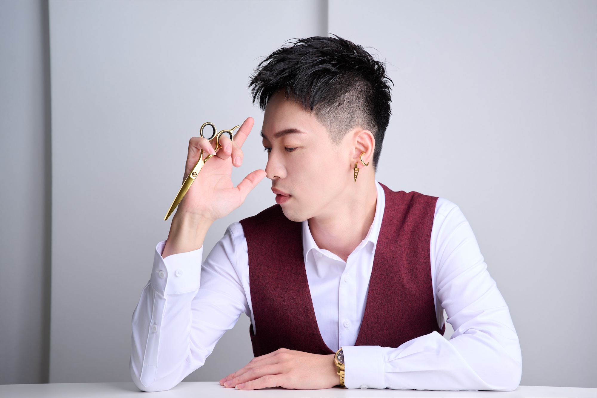 男性理髮師專業形象，搭配理髮電剪與西裝外套配色，達成畫面專業的一致性。