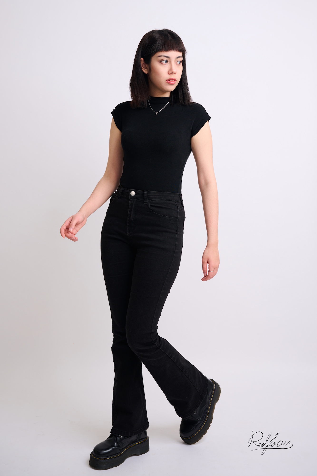 台南形象照推薦：專業模特兒作品集（Model Card）。模特兒身穿全黑高領短袖與修身長褲，以具節奏感的步態展現俐落的身形比例與深邃眼神。適合模特兒經紀公司、服裝品牌宣傳及個性肖像攝影。