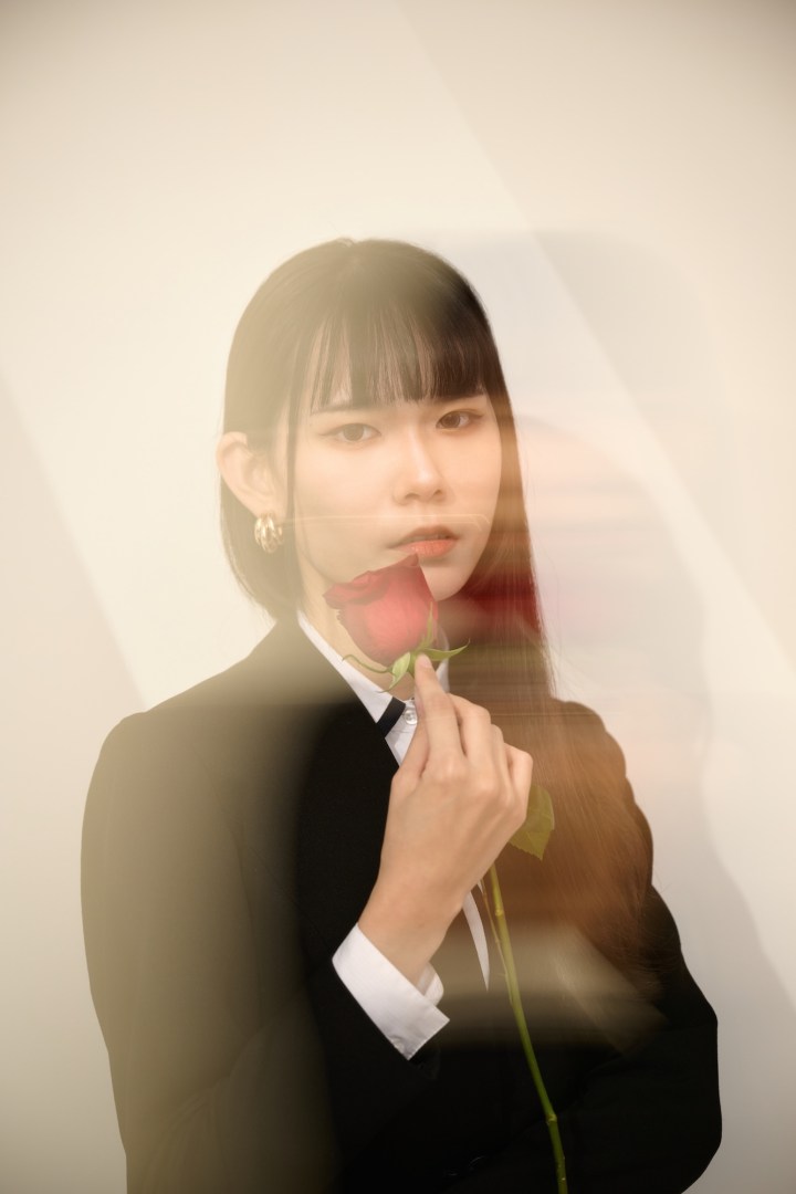 台南形象寫真推薦：知性女性身穿黑西裝手持紅玫瑰，展現神秘且具備时尚張力的藝術肖像。適合個人品牌核心視覺、藝術攝影作品集及社群媒體獨特形象展示。