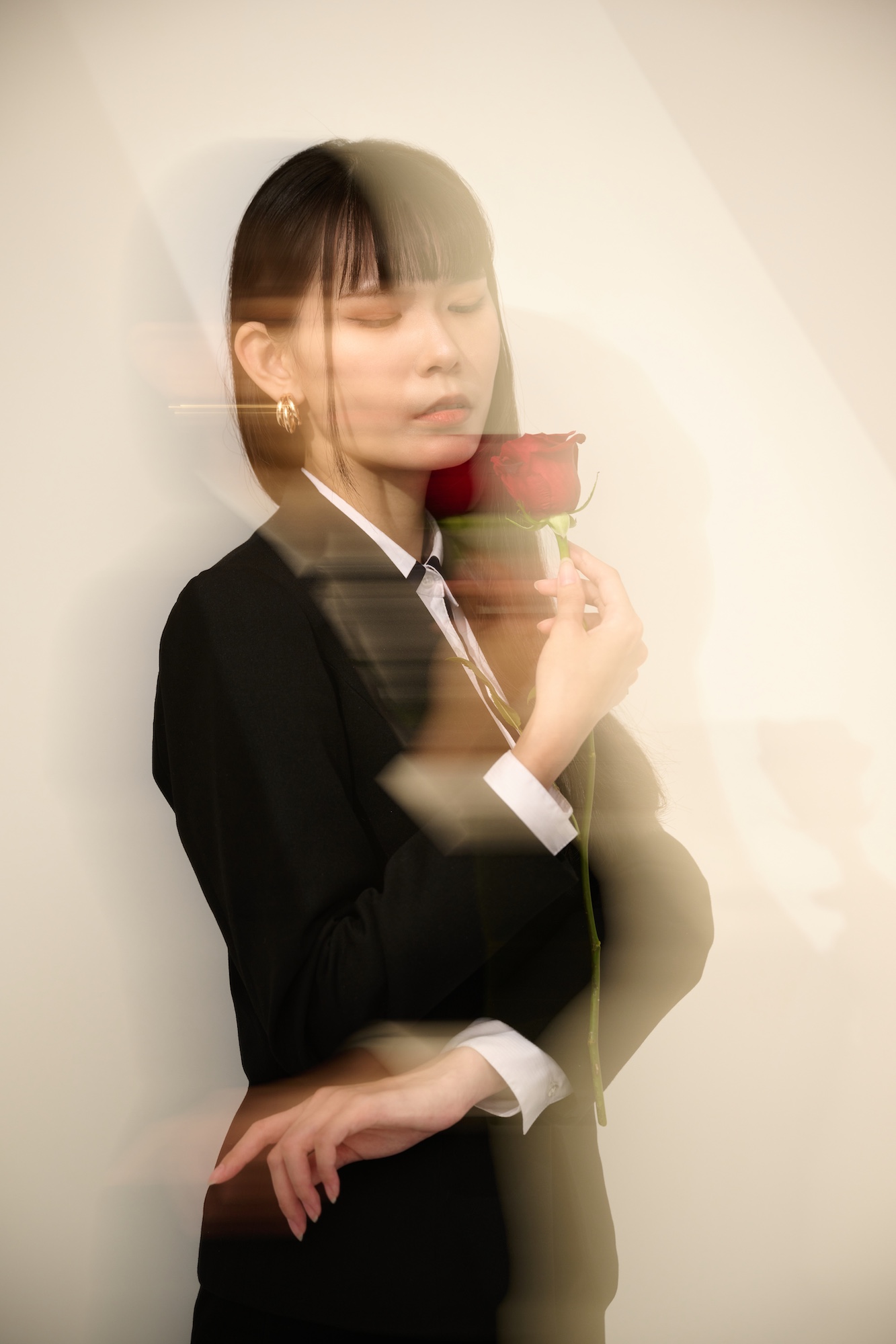 台南形象寫真：利用光影晃動特效，展現女性閉眼執玫瑰的夢幻神韻。畫面充滿藝術流動感，適合用於個人品牌的美學故事、藝術攝影作品集或強調感性特質的視覺頁面。