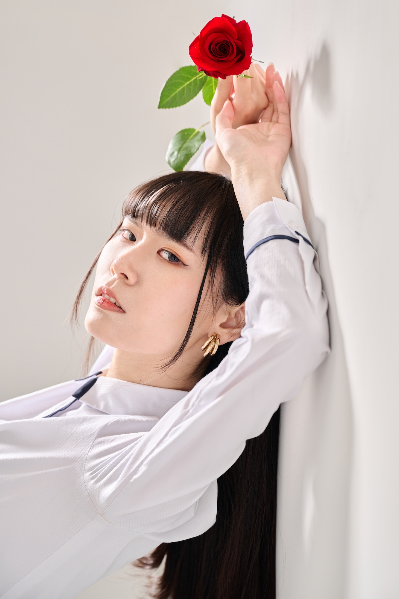 台南形象寫真：女性執玫瑰輕靠牆面展現時尚美感，構圖大膽且具備藝術張力。適合個人品牌核心視覺、時尚美妝專欄或強調質感的生活風格頁面。