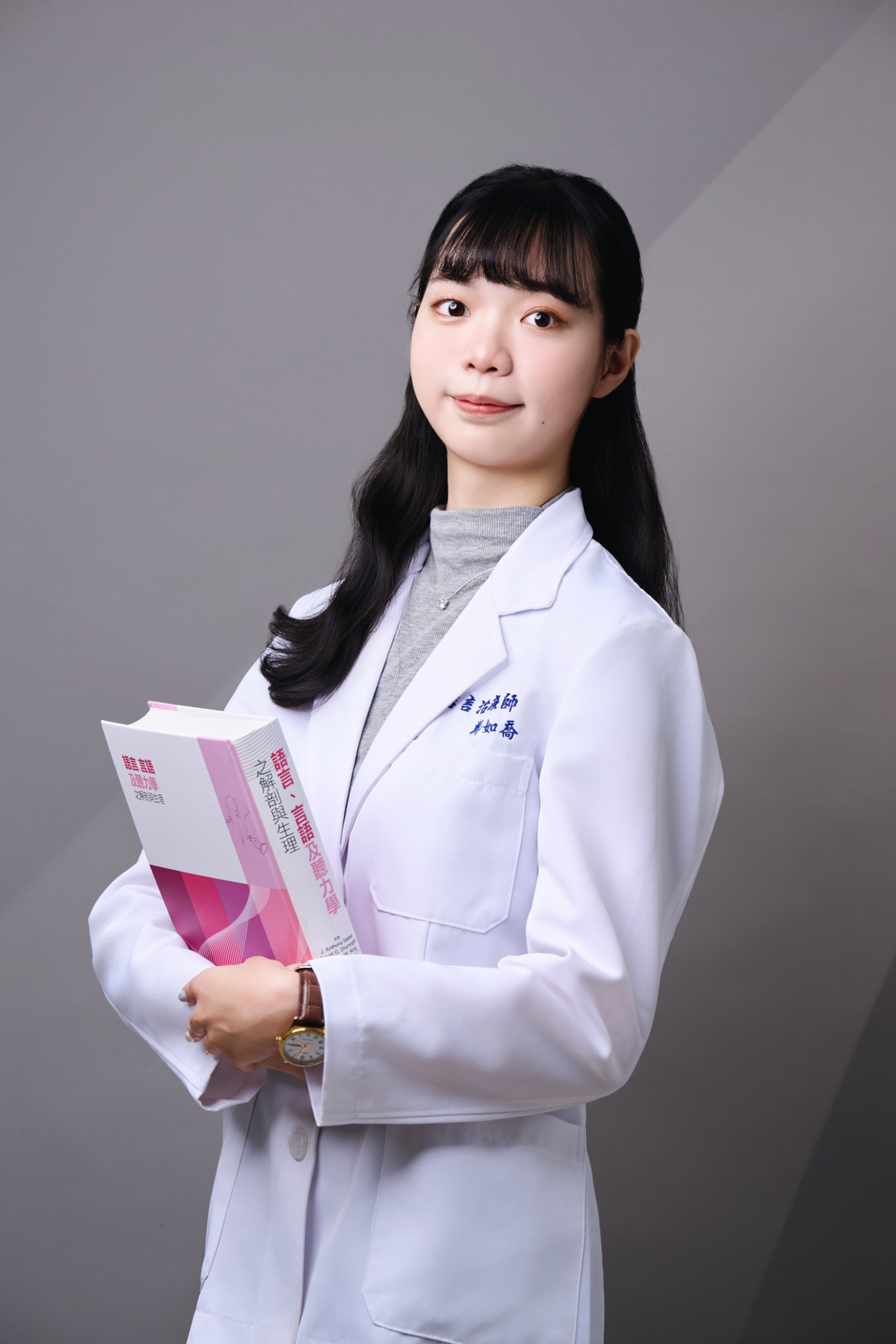 台南語言治療師形象照推薦：治療師懷抱語言及聽力學專業書籍，展現嚴謹的學術背景與專業臨床素養。適合用於治療師簡歷、學術專欄封面或專業醫療團隊介紹。