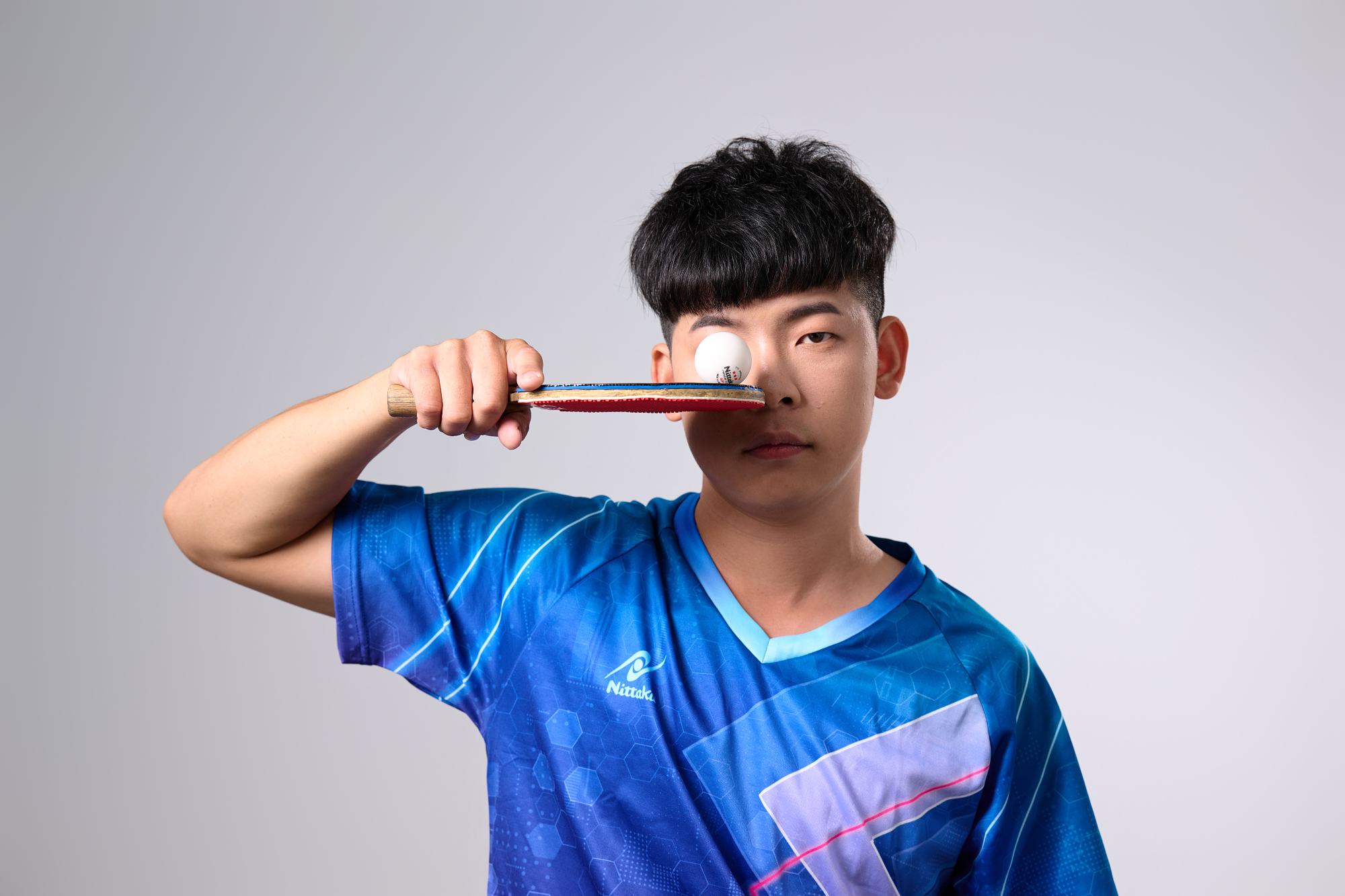 台南桌球教練形象照：教練展示乒乓球平衡控球技術，眼神專注冷靜，展現精準的教學實力與運動職人精神。適合桌球教室官網、運動員個人品牌與專業課程推廣。