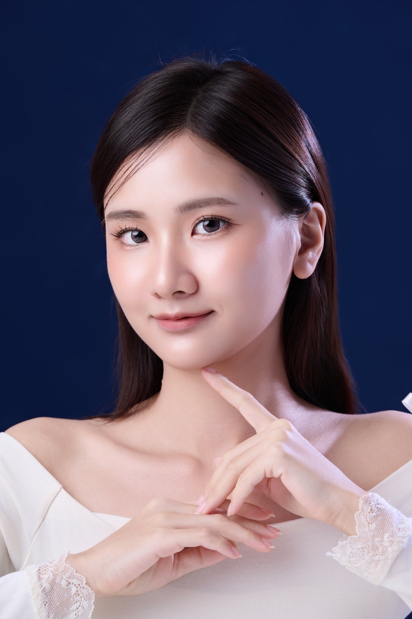 台南形象照推薦：高品質韓系風格女性肖像。白領平口服飾搭配精緻蕾絲袖口，展現溫柔優雅氣質。深藍色背景突顯通透膚質與細膩光影，適合個人品牌、美妝宣傳與演藝形象照。