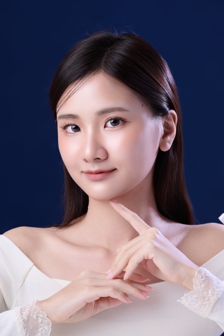 台南形象照推薦：高品質韓系風格女性肖像。白領平口服飾搭配精緻蕾絲袖口，展現溫柔優雅氣質。深藍色背景突顯通透膚質與細膩光影，適合個人品牌、美妝宣傳與演藝形象照。