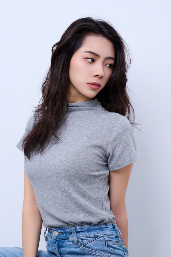 台南形象照推薦：清新自然風格女性形象攝影。長捲髮女性身穿灰色高領上衣與牛仔褲，展現優雅側面神韻。適合個人品牌、社群頭像與生活質感寫真。