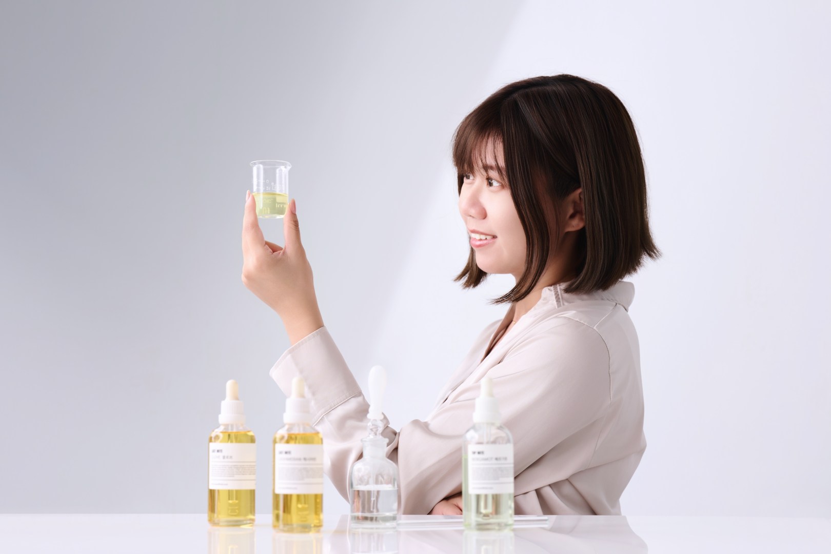 台南形象照推薦：調香師專業職人攝影。捕捉女性調香師專注觀察燒杯內精油的瞬間，搭配質感香氛瓶，展現個人品牌專業魅力與自然氣質。